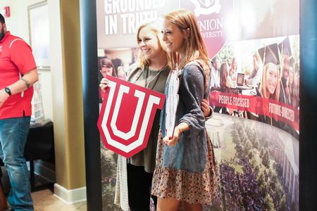 Day at the U guests enjoy the photo booth set up during a session in the Grant Events Center. - Photo by Kristi McMurry Woody