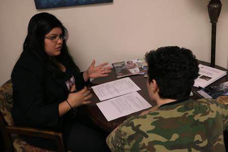 Alma Hernandez, employer relations & recruitment manager, assists a senior on his resumé during the Walk-in Monday resumé help event. - Photo by Elizabeth Wilson