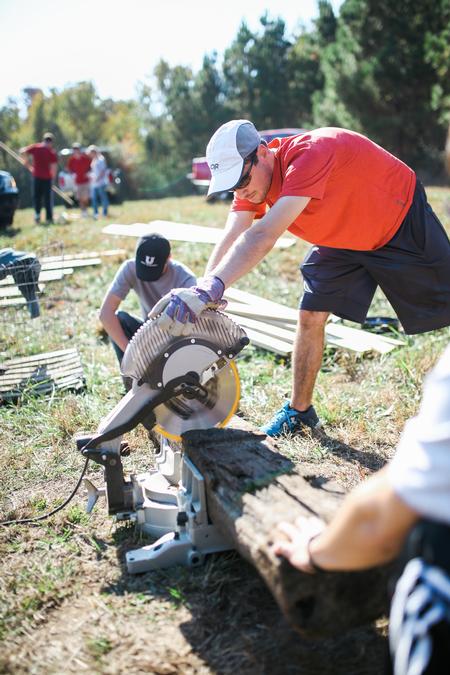 Members of the engineering and athletic training departments work together to build a mountain bike skills trail during Campus & Community Day. - Photo by Kristi McMurry Woody