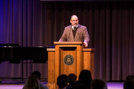 Dr. Scott Huelin, director of the Honors Program addresses students in the G.M. Savage Memorial Chapel.  - Photo by Morgan Morfe