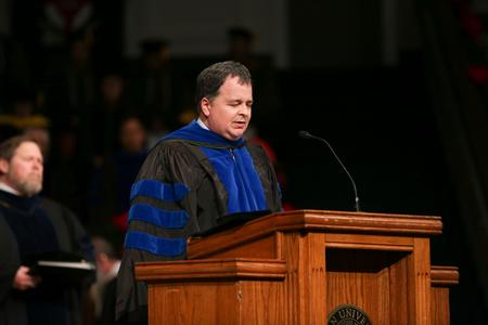 Matt Lunsford, professor of mathematics, prays at the beginning of fall commencement.  - Photo by Kristi McMurry Woody