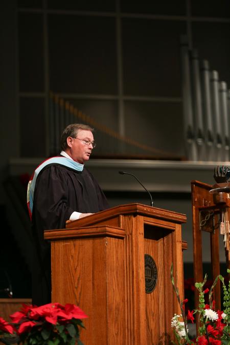 Tommy Sadler, director of athletics, reads scripture during fall commencement.  - Photo by Kristi McMurry Woody