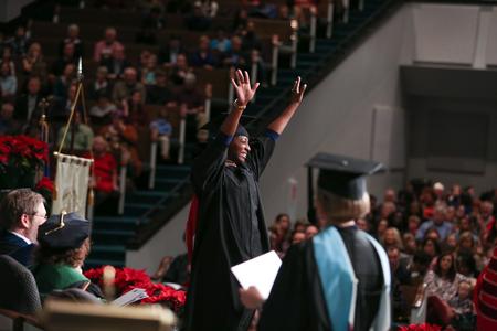 Desireé Blow, MBA graduate, walks excitedly to receive her diploma during fall commencement. - Photo by Kristi McMurry Woody