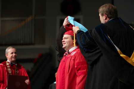 Josh Clarke, doctor of education, is presented with his doctoral hood during fall commencement.  - Photo by Kristi McMurry Woody