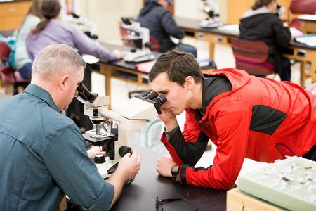Marc Lockett, associate professor of biology, looks at a slide with a student during histology lab. - Photo by Kristi McMurry Woody