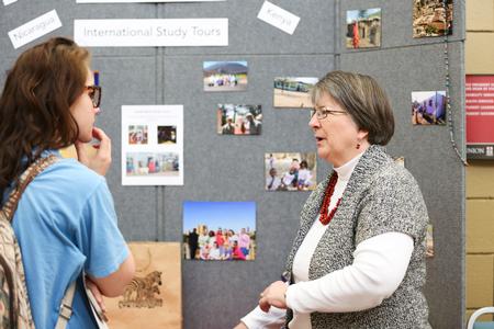 Mary Ann Poe, professor of social work, talks to guests at the Study Abroad Fair in the SUB. - Photo by Kristi McMurry Woody