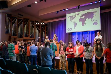 Members of several GO Trip teams gather in front of the chapel as everyone prays for the various trips taking place over spring break. - Photo by Kristi McMurry Woody