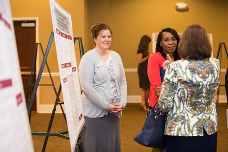 Kimberly Thompson, MSN student, presents her project during the annual Scholarship Symposium poster presentations in the Grant Events Center.  - Photo by Kristi McMurry Woody