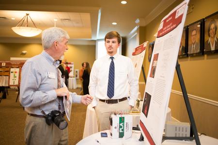 Addison Turner, sophomore engineering major, talks to Bill Nettles, university professor of physics and department chair, about his project during the Scholarship Symposium. - Photo by Kristi McMurry Woody