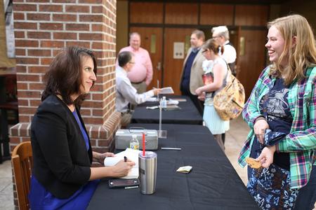 Chris Bailey, associate professor of English and director of composition support, signs copies of her book after presenting a reading.  - Photo by Kristi McMurry Woody