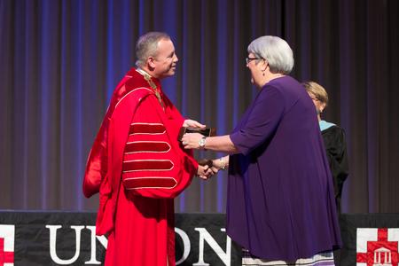 Dub Oliver, president of the university, congratulates Wendy Glass, campus director and assistant registrar for the Germantown campus, on being named Staff Member of the Year during Awards Day chapel. - Photo by Kristi McMurry Woody