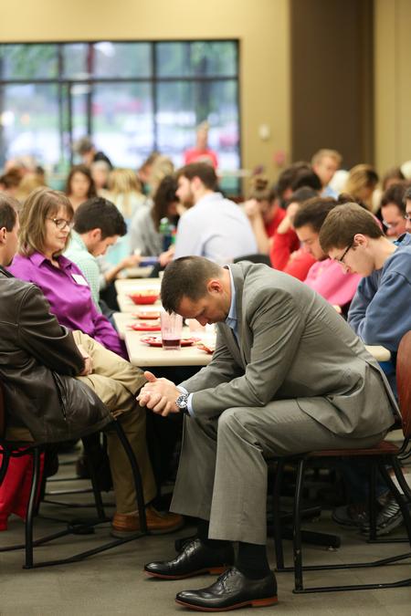 Bryan Carrier, vice president for student life and dean of students, prays during the prayer breakfast in the Brewer Dining Hall. - Photo by Kristi McMurry Woody