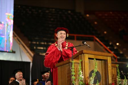 Dub Oliver, president of the university, applauds the 2017 graduates during spring commencement.  - Photo by Kristi McMurry Woody
