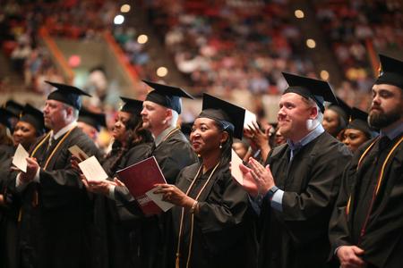 Graduates applaud as they prepare to receive their diplomas at spring commencement. - Photo by Kristi McMurry Woody