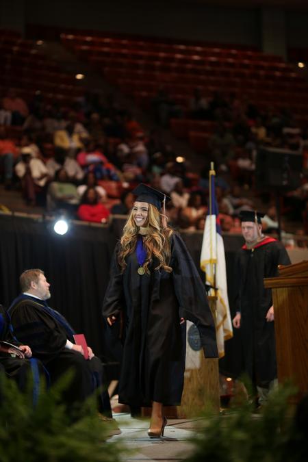 Camila Simas, MBA graduate, walks across the stage to receive her diploma during spring commencement.  - Photo by Kristi McMurry Woody