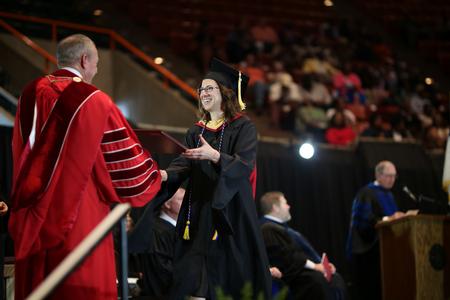 Sarah Belcher, master of social work graduate, receives her diploma from Dub Oliver, president of the university, during spring commencement.  - Photo by Kristi McMurry Woody