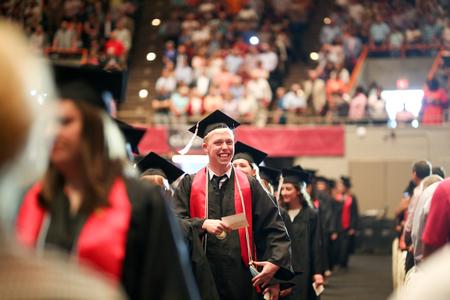 Garyn McIntyre, French graduate, smiles as he processes into spring commencement with his classmates.  - Photo by Kristi McMurry Woody