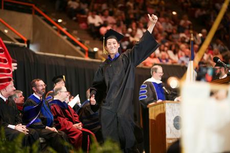 Sam Jeong, engineering graduate, celebrates as he crosses the stage to receive his diploma during spring commencement.  - Photo by Kristi McMurry Woody