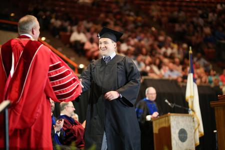 Ethan Wilson, one of the first graduates of the Union EDGE program, receives his post-secondary certificate of completion from Dub Oliver, president of the university. - Photo by Kristi McMurry Woody