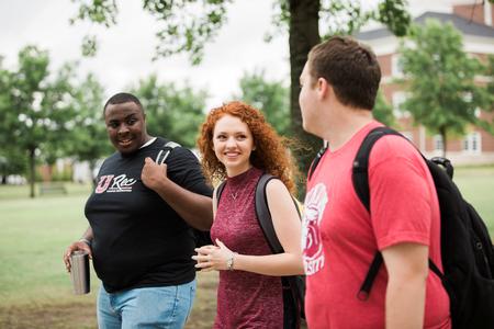 Justice Walker, junior mathematics major, Mattanah DeWitt, freshman journalism major, and Trenton Holloway, junior psychology major, walk along the Great Lawn. - Photo by Kristi McMurry Woody