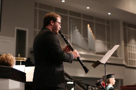 Jordan Mathenia, senior music major, plays "Great is Thy Faithfulness" on the clarinet during summer commencement. - Photo by Kristi McMurry Woody