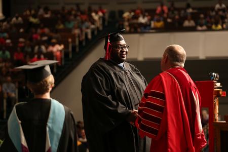 Scott Jones, social work graduate, receives his diploma during summer commencement. - Photo by Kristi McMurry Woody