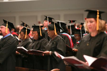 Graduates join the rest of the crowd in singing the Alma Mater at the conclusion of summer commencement. - Photo by Kristi McMurry Woody
