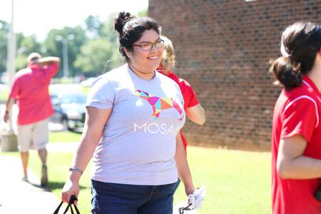 Alma Hernandez, employer relations and recruitment manager for the Vocatio Center, helps carry boxes during new student move-in day. - Photo by Kristi McMurry Woody