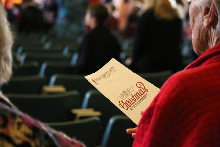 An audience member holds a program for the Christmas chapel service. - Photo by Hannah Heckart