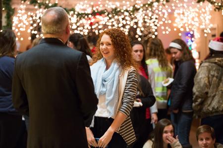 Mattanah DeWitt, journalism major, talks with Dub Oliver, president of the university, at the Christmas with the Olivers event.  - Photo by Kristi McMurry Woody