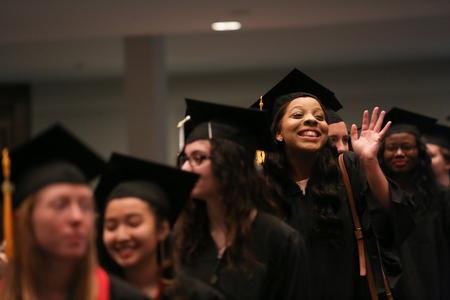 Angelica Shipps, communication studies graduate, waves as she spots friends and family in the crowd at fall graduation. - Photo by Kristi McMurry Woody