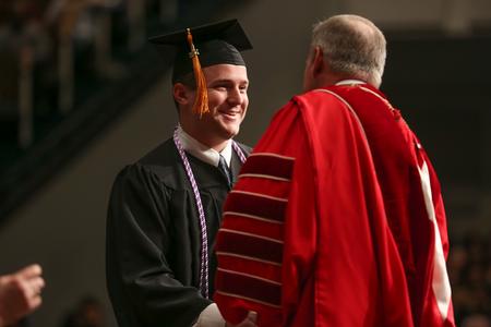 Jonathan Walker Buchanan, nursing graduate, receives his diploma from Dub Oliver, president of the university, during fall graduation. - Photo by Kristi McMurry Woody