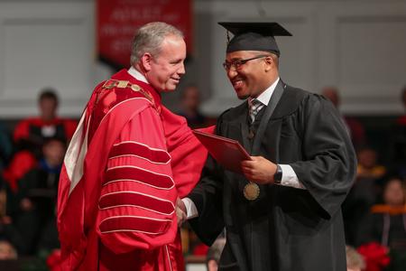 Dub Oliver, president of the university, congratulates Victor Jerome Comer II, business administration graduate, as he receives his diploma during fall graduation.  - Photo by Kristi McMurry Woody