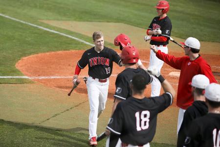 Bulldog baseball players congratulate Chase Diggs after he scored a run in a game against Harding University. - Photo by Kristi McMurry Woody