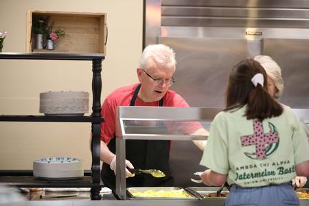 Robbie Graves, assistant vice president for undergraduate admissions, serves breakfast to students during Food for Finals. - Photo by Kristi McMurry Woody