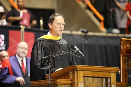 Gary Carter, senior vice president for business services, reads from 1 Thessalonians during spring commencement services.  - Photo by Kristi McMurry Woody