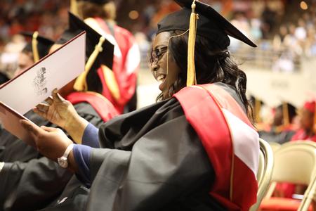 Tracy McClain, master of social work graduate, looks at her diploma during spring commencement services.  - Photo by Kristi McMurry Woody