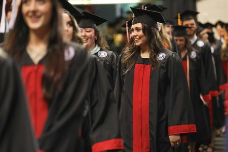 Lauren Castellaw, music education graduate, looks for her family and friends as she processes into spring commencement services with her fellow graduates.  - Photo by Kristi McMurry Woody
