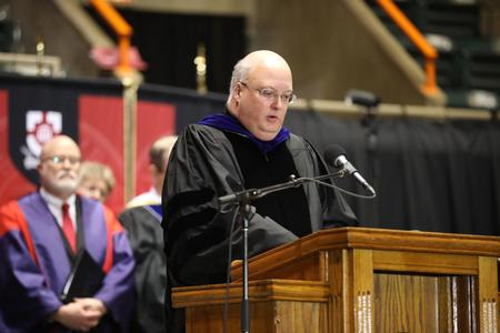 Bryan Dawson, university professor of mathematics, reads from 1 Thessalonians at the beginning of spring commencement services.  - Photo by Kristi McMurry Woody