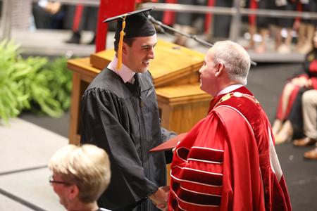 Hugo Gaspar, computer science graduate, receives his diploma from the university president during spring commencement services.  - Photo by Kristi McMurry Woody