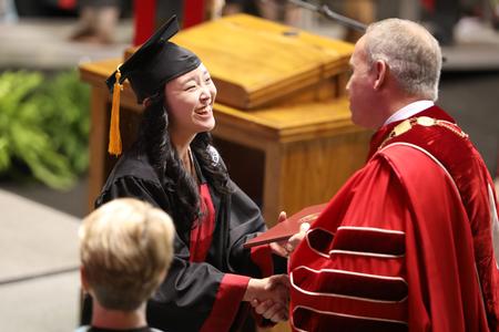 Yee Eun Lee, cell and molecular biology graduate, receives her diploma from Dub Oliver, president of the university, during spring commencement services.  - Photo by Kristi McMurry Woody