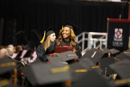 Tiffany Roberts, nursing graduate, walks back to her seat after receiving her diploma at spring commencement services.  - Photo by Kristi McMurry Woody