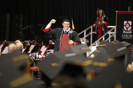 Braden Smith, nursing graduate, celebrates after receiving his diploma during spring commencement services.  - Photo by Kristi McMurry Woody