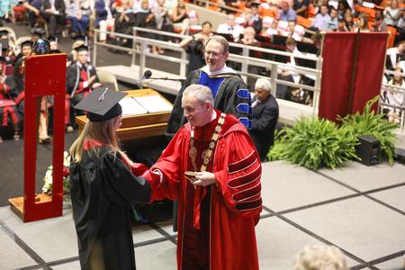Dub Oliver, president of the university, awards Janey Berends, Spanish and applied linguistics graduate, with the Tigrett Medal at the conclusion of spring commencement services.  - Photo by Kristi McMurry Woody