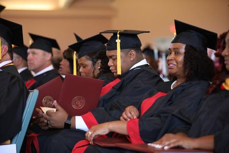 Organizational leadership students check out their diplomas during summer graduation. - Photo by Kristi McMurry Woody