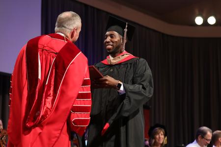 Jermaine Jones, master of business administration graduate, receives his diploma during summer graduation. - Photo by Kristi McMurry Woody