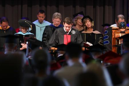 Chad Wilson, vice chair of the board of trustees, gives the benediction during summer graduation. - Photo by Kristi McMurry Woody