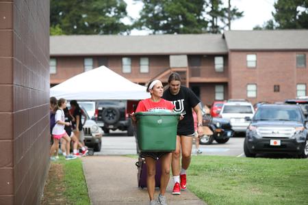 Karen Sinclair, assistant professor of athletic training education, and Christa Karns, senior social work major, help new students move in during Welcome Week. - Photo by Kristi McMurry Woody