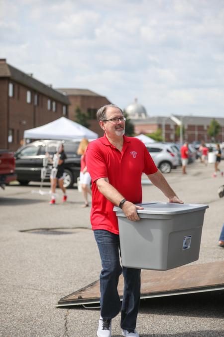 John Netland, provost and vice president for academic affairs, helps unload a trailer during new student move-in day. - Photo by Kristi McMurry Woody