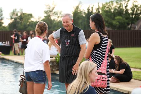 Dub Oliver, president of the university, laughs with new students during the Welcome Week ice cream party at the Oliver home. - Photo by Kristi McMurry Woody